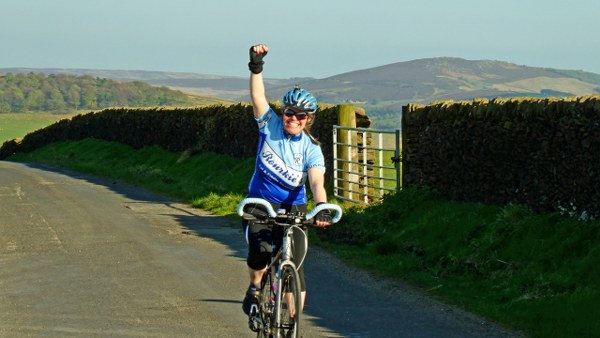 Helen raises her arm in triumph as we top out over the last climb of the day