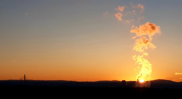 The sun sets above Flint power station on a Wirral ride