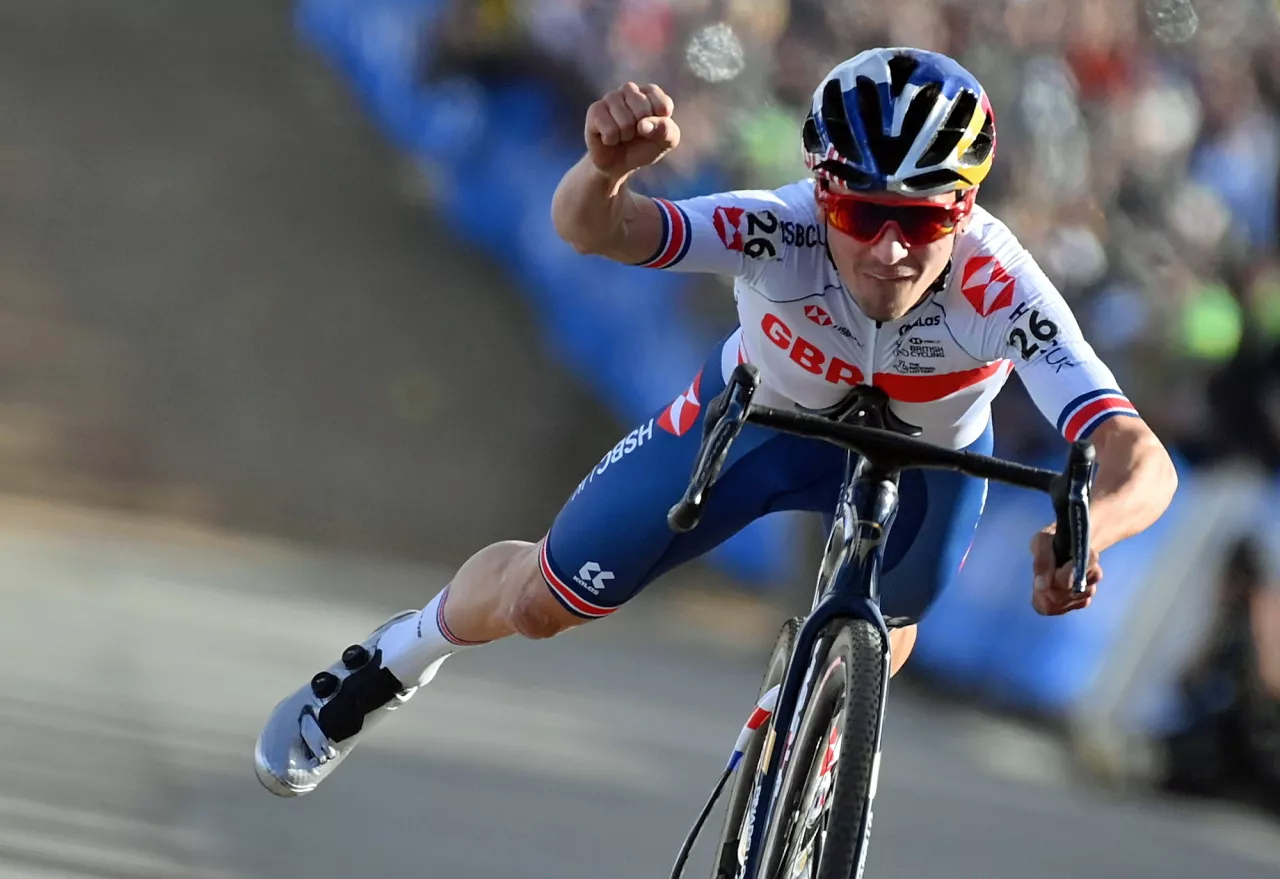 Tom Pidcock adopts the Superman position as he wins the Cyclocross Worlds